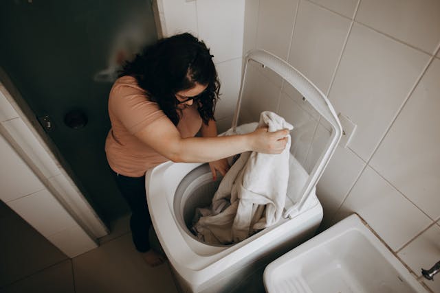 Perbezaan Mesin Basuh Front Load dan Top Load - Cucian Mana Yang Lebih Bersih? Photo by Helena Lopes: https://www.pexels.com/photo/woman-putting-clothes-to-washing-machine-27177590/